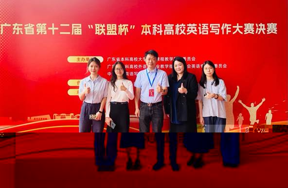 A group of people standing in front of a red wall Description automatically generated